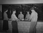 [Students at the circulation desk of Emmanuel Missionary College library]