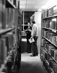 [Andrew Levay and friend in James White Library stacks] by James White Library