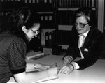 [Kit Watts assisting someone in the James White Library] by James White Library